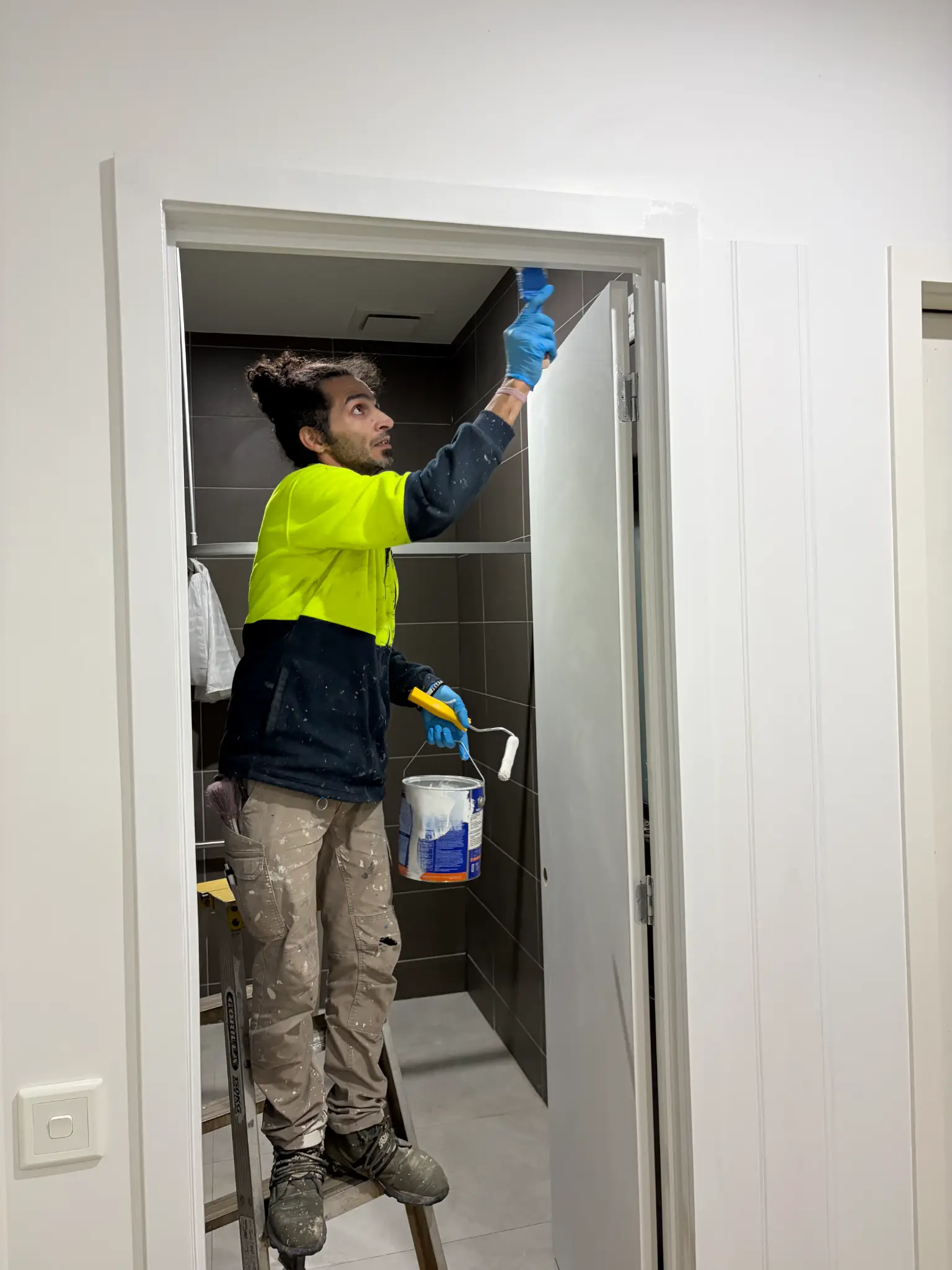 Home Hero Services team member preparing an interior doorway for painting
