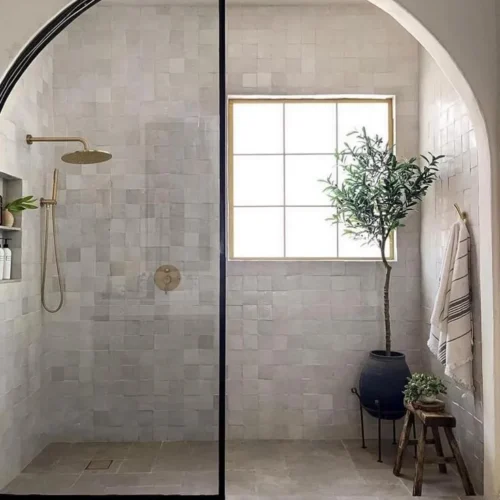 Black and gold bathroom with green plant inside