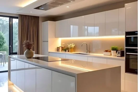 Ultra-Modern White Kitchen with Ambient Lighting A luxurious, ultra-modern white kitchen featuring glossy cabinets, a large island with integrated hob, and extensive warm LED accent lighting under the island and wall cabinets.